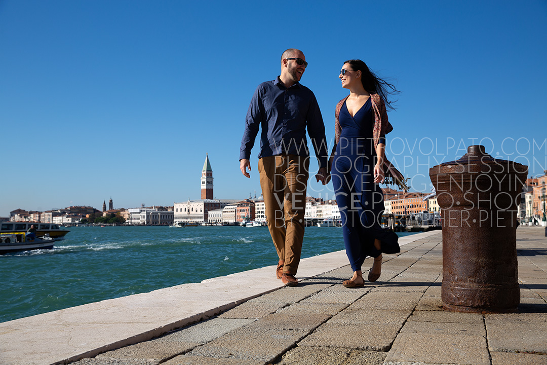 A couple enjoying a stroll during an engagement photography session, with the Piazza San Marco far away in the background.