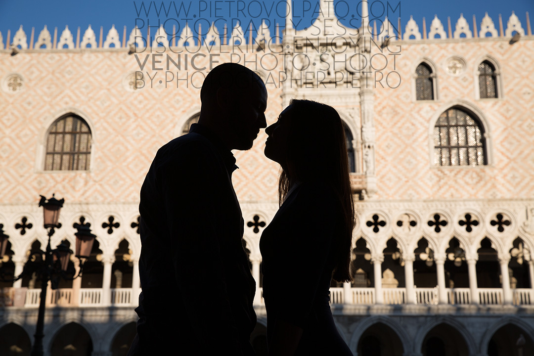 A silhouette photo of a couple almost kissing against the Doge's Palace in St. Mark's Square.