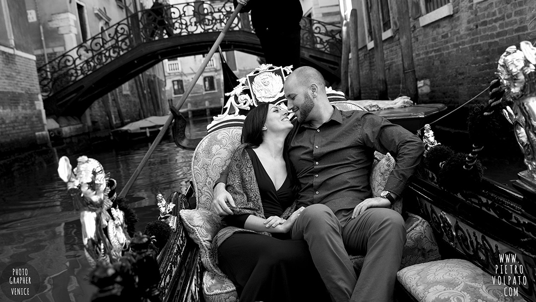 A couple enjoying a romantic moment during a gondola ride. A photo part of an engagement photography session in Venice.
