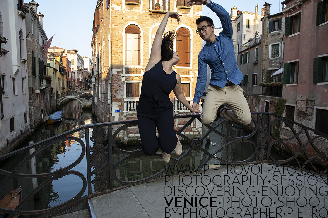 A couple jumping on a bridge in Venice during the sunset time.