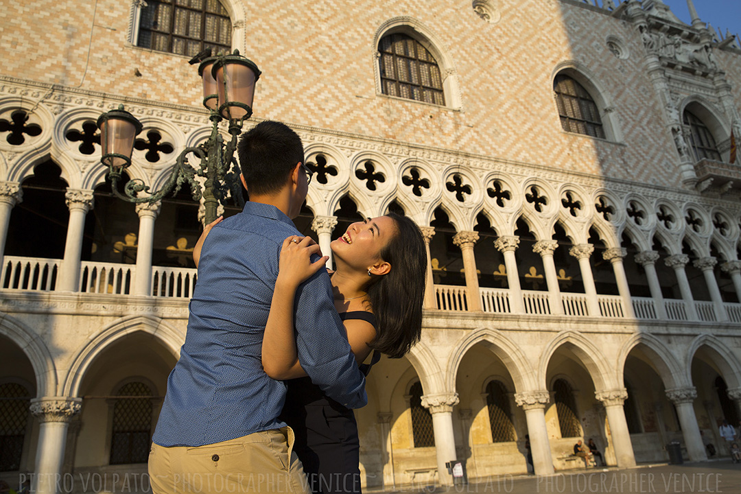 A couple having fun in front of the Doge Palace in Venice. This photo is a part of a vacation and portrait photo shoot provided by photographer Pietro.